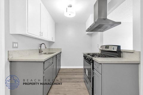a kitchen with white cabinets and stainless steel appliances and a stove